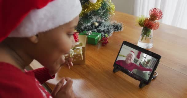 戴桑塔帽的非洲裔美国女人用平板电脑打圣诞视频电话 男人在屏幕上 圣诞节 节日和通信技术 — 图库视频影像
