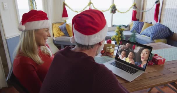 Uśmiechnięta Kaukaska Para Kapeluszami Mikołaja Korzystająca Laptopa Świąteczną Rozmowę Wideo — Wideo stockowe