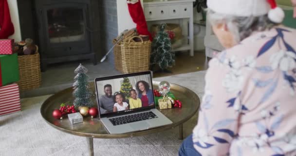 画面上の笑顔の家族とクリスマスのビデオ通話のためのラップトップを使用してシニア白人女性 クリスマスやお祭りや通信技術は — ストック動画
