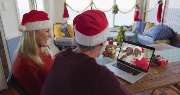 Uśmiechnięta Kaukaska Para Kapeluszami Mikołaja Korzystająca Laptopa Świąteczną Rozmowę Wideo — Wideo stockowe
