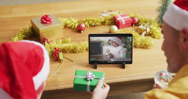 白人父亲和儿子与桑塔帽子使用石碑圣诞节视频通话与男孩在屏幕上 圣诞节 节日和通信技术 — 图库视频影像
