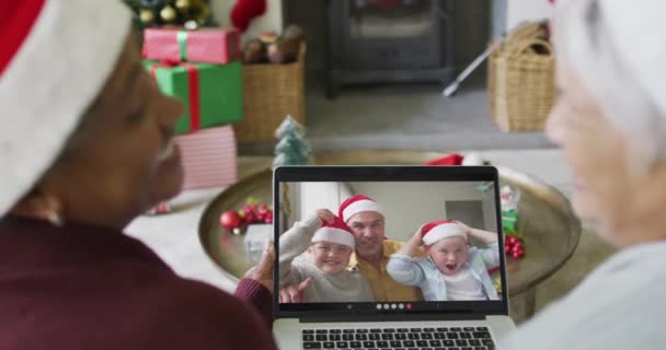 两个不同的高级女友用笔记本电脑和家人在屏幕上进行圣诞视频通话 圣诞节 节日和通信技术 — 图库视频影像