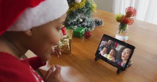 戴圣诞礼帽的非洲裔美国女人用平板电脑打圣诞视频 家里也在荧幕上 圣诞节 节日和通信技术 — 图库视频影像