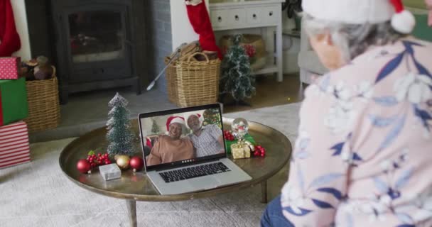 高年级的高加索女人用笔记本电脑进行圣诞视频通话 屏幕上有一对微笑的夫妇 圣诞节 节日和通信技术 — 图库视频影像