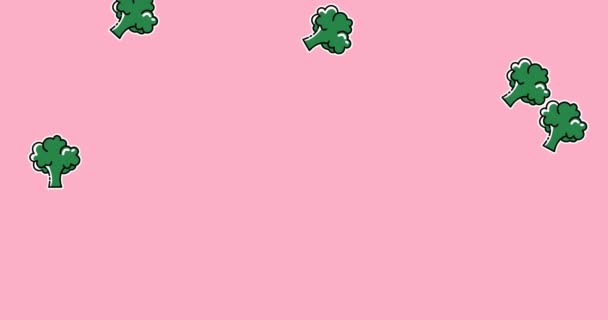 淡いピンクの背景に落ちる緑のブロッコリーのアニメーション 食と栄養の概念をデジタルで生成し — ストック動画