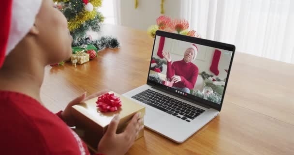 戴桑塔帽的非洲裔美国女人用笔记本电脑打圣诞视频电话 男人在屏幕上 圣诞节 节日和通信技术 — 图库视频影像
