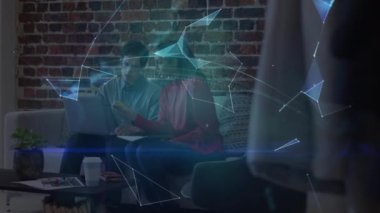 Dizüstü bilgisayarla çalışan erkek ve kadın meslektaşlar üzerinde ışıldayan küresel ağın animasyonu. küresel iletişim ağı teknolojisi konsepti dijital olarak oluşturulmuş video.