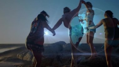 Güneşli sahilde el ele tutuşan kadın arkadaşların üzerinde ışıldayan küresel ağın animasyonu. küresel iletişim teknolojisi, boş zaman ve seyahat konsepti dijital olarak oluşturulmuş video.