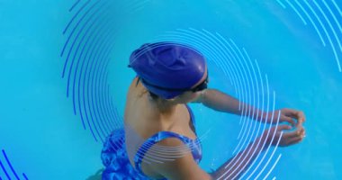 Havuzda yüzen bir kadının üzerinde dönen mavi çizgili spiral animasyon. spor ve spor konsepti, dijital olarak üretilen video.