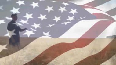 İnsanlarla birlikte Amerikan bayrağının dalgalandığı animasyon buğday tarlasında dikilmiş başka tarafa bakıyordu. Vatanseverlik, bağımsızlık ve tarım kavramı dijital olarak üretilen video.