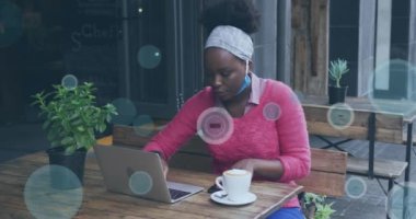 Kafe dışında dizüstü bilgisayar kullanan Afro-Amerikan bir kadının 5G ve 6G simgelerinin animasyonu. küresel iletişim teknolojisi ve sosyal ağ konsepti dijital olarak oluşturulmuş video.