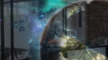 Ofiste akıllı telefon ve dizüstü bilgisayar kullanan bir adam üzerinde ışıldayan küresel iletişim ağının animasyonu. küresel iletişim ağı ve dijital arayüz teknolojisi konsepti dijital olarak oluşturulmuş video.