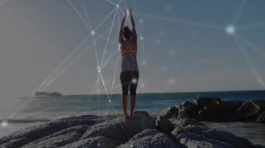 Deniz kenarında kollarını kaldıran kadın üzerinde ışıldayan küresel ağın animasyonu. küresel iletişim teknolojisi, boş zaman ve seyahat konsepti dijital olarak oluşturulmuş video.