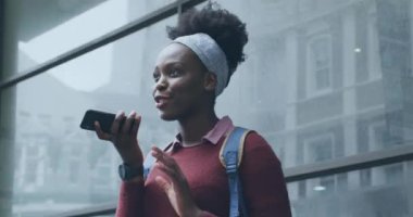 Şehirde akıllı telefondan konuşan Afrikalı Amerikalı bir kadın hakkında sosyal medya bildirimleri. küresel iletişim teknolojisi ve sosyal ağ konsepti dijital olarak oluşturulmuş video.