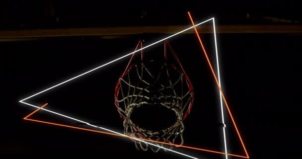 バスケットボール選手の得点フープの上にオレンジと白のネオン三角形のアニメーション スポーツ競争技術の概念デジタルで生成されたビデオ — ストック動画