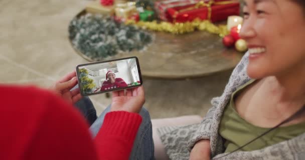 画面上の女性とクリスマスのビデオ通話のためのスマートフォンを使用して笑顔アジアのカップル クリスマスやお祭りや通信技術は — ストック動画