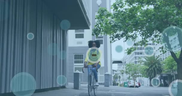 Animation Icônes Sur Femme Afro Américaine Vélo Dans Rue Ville — Video
