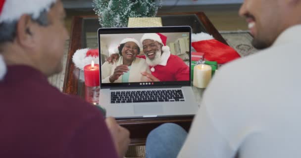 画面上の幸せなカップルとクリスマスのビデオ通話のためのラップトップを使用して出産の父と息子を笑顔 クリスマスやお祭りや通信技術は — ストック動画