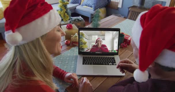 Uśmiechnięta Kaukaska Para Kapeluszami Mikołaja Używająca Laptopa Świątecznej Rozmowy Wideo — Wideo stockowe