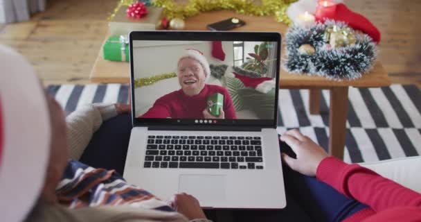 アフリカ系アメリカ人の母親と娘がノートパソコンを使ってクリスマスのビデオ通話をしている クリスマスやお祭りや通信技術は — ストック動画