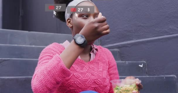 アフリカ系アメリカ人女性に対するソーシャルメディア上の通知のアニメーションは 市内で持ち帰りを食べる 地球規模の通信技術とソーシャルネットワークの概念デジタルで生成されたビデオ — ストック動画