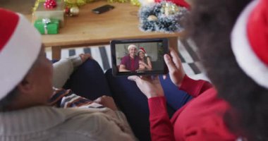 Afrika kökenli Amerikalı anne ve kız. Yılbaşı videoları için ekranda bir çiftle tablet kullanıyorlar. Noel, şenlik ve iletişim teknolojisi.
