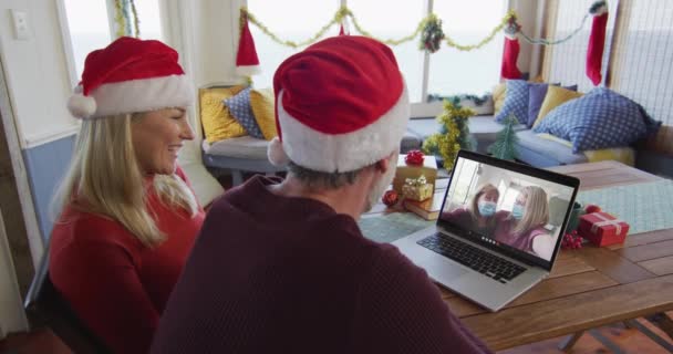 Sonriente Pareja Caucásica Con Sombreros Santa Usando Ordenador Portátil Para — Vídeo de stock