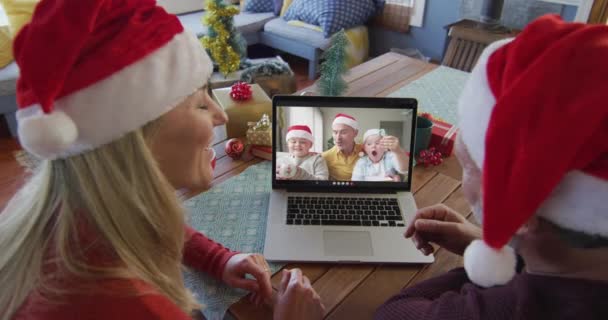 Lächelndes Kaukasisches Paar Mit Weihnachtsmannmützen Das Seinen Laptop Für Ein — Stockvideo