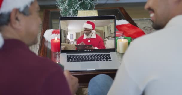 Biracial Padre Hijo Con Sombreros Santa Usando Ordenador Portátil Para — Vídeos de Stock