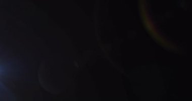 Karanlık arka planda yanıp sönen mercekli spot ışıklarının canlandırması. hareket, enerji ve ışık, soyut arayüz arkaplan kavramı dijital olarak oluşturulmuş video.