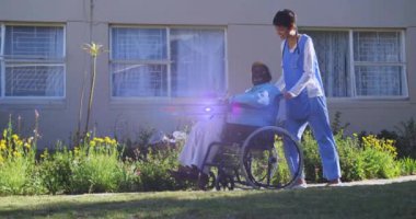 Işık animasyonu, yaşlı adamı tekerlekli sandalyeyle iten kadın hemşirenin üzerinden geçiyor. emeklilik, ev hayatı ve umut kavramı dijital olarak oluşturulmuş animasyon.