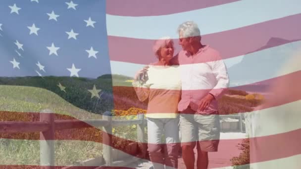 Animacja Szczęśliwej Starszej Kaukaskiej Pary Obejmującej Plaży Flagę Stanów Zjednoczonych — Wideo stockowe