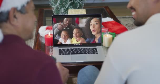 Бирасенсовый Отец Сын Шляпах Санты Используют Ноутбук Рождественского Видео Звонка — стоковое видео