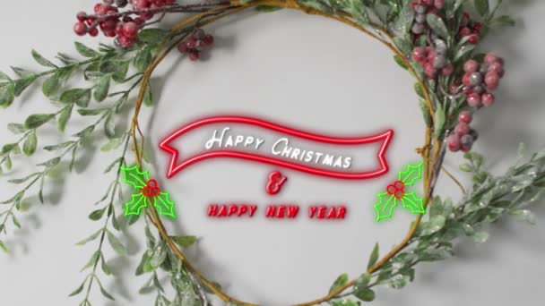 ネオンメリークリスマスと灰色の表面に花輪の装飾に対する幸せな新年のテキストバナー クリスマス フェスティバルとお祝いのコンセプト — ストック動画