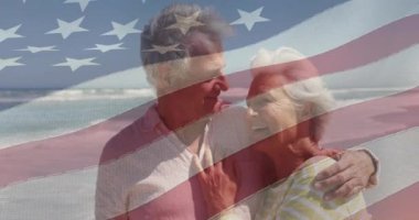 Amerika Birleşik Devletleri bayrağı üzerinde kumsalda kucaklaşan mutlu yaşlı beyaz çiftin animasyonu. Amerikan vatanseverliği, tatil ve emeklilik konsepti dijital olarak oluşturulmuş video.