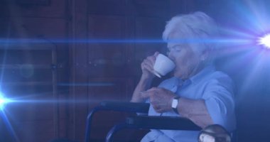 Işık animasyonu, yaşlı, tekerlekli sandalyede oturan ve evinde kahve içen beyaz kadının üzerinde hareket ediyor. emeklilik, ev hayatı ve umut kavramı dijital olarak oluşturulmuş animasyon.