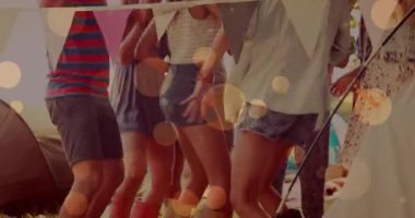 Plaj partisinde dans eden arkadaşlarının üzerinde parlayan sarı ışıkların animasyonu. parti ve kutlama konsepti dijital olarak oluşturulmuş video.