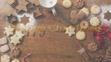 Ahşap yüzeyde noel kurabiyelerine karşı mutlu noel afişleri ve portakal parçacıkları. Noel şenliği ve kutlama konsepti
