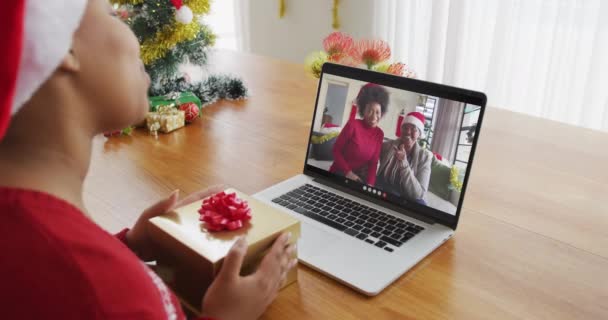 Afroamerikanerin Mit Weihnachtsmütze Mit Laptop Für Weihnachtsvideotelefonie Mit Familie Auf — Stockvideo