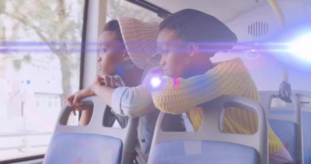 Animacja Niebieskiej Wiązki Światła Nad Dwiema Afrykańskimi Amerykankami Autobusie Wyglądającymi — Wideo stockowe