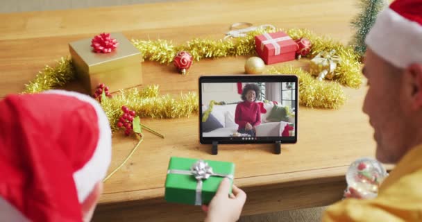画面上の女性とクリスマスのビデオ通話のためのタブレットを使用してサンタの帽子を持つ白人の父と息子 クリスマスやお祭りや通信技術は — ストック動画