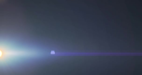 暗い背景にレンズフレアと光ビームが動くスポットライトのアニメーション 動きエネルギー光抽象的インターフェースの背景概念デジタル的に生成されたビデオ — ストック動画