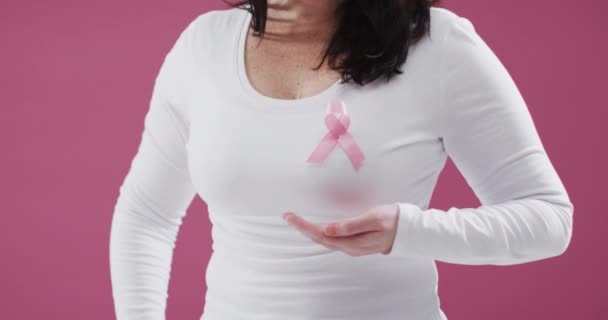 乳腺癌意识文字横幅反对中间部分的妇女穿着粉红缎带在胸前 乳腺癌意识概念 — 图库视频影像