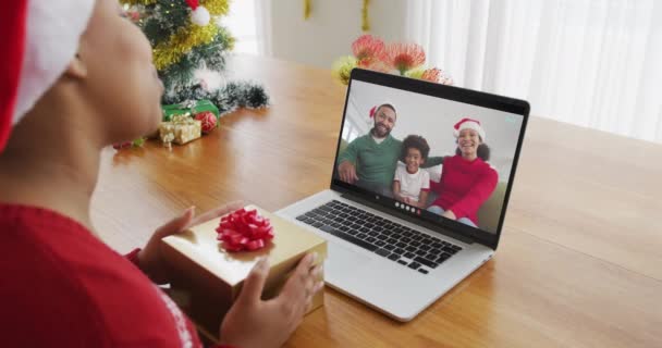 戴桑塔帽的非洲裔美国女人用笔记本电脑和家人在屏幕上进行圣诞视频通话 圣诞节 节日和通信技术 — 图库视频影像