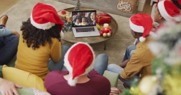 不同的家庭与桑塔帽使用笔记本电脑圣诞节视频通话与快乐的家庭在屏幕上 圣诞节 节日和通信技术 — 图库视频影像