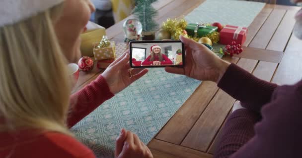 Blank Echtpaar Met Santa Hoeden Met Behulp Van Smartphone Voor — Stockvideo