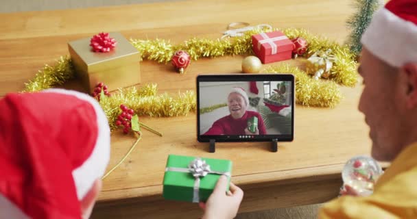 白种人的父亲和儿子 戴着桑塔帽 用平板电脑和屏幕上的男人打圣诞视频电话 圣诞节 节日和通信技术 — 图库视频影像