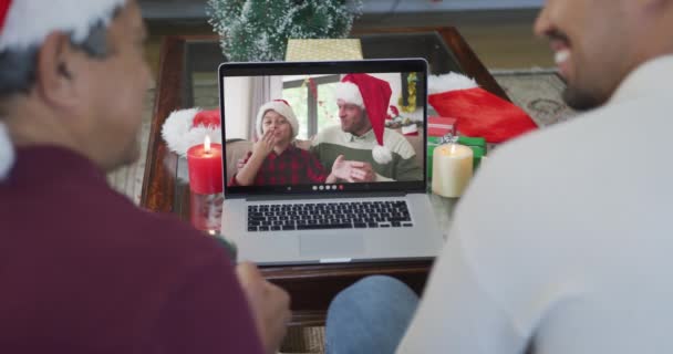 Улыбающиеся Двуликие Отец Сын Используют Ноутбук Рождественского Видео Звонка Семьей — стоковое видео