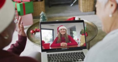 Ekrandaki kadınla yılbaşı videosu için birçok üst düzey bayan arkadaş dizüstü bilgisayar kullanıyor. Noel, şenlik ve iletişim teknolojisi.