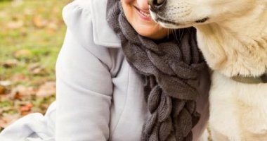 Parkta Golden Retriever köpeğini kucaklayan mutlu Kafkas kıdemli kadın. Köpek sahipliğini, bakım ve sadakat konseptini dijital olarak üretilmiş videolarınızı gezdirin.